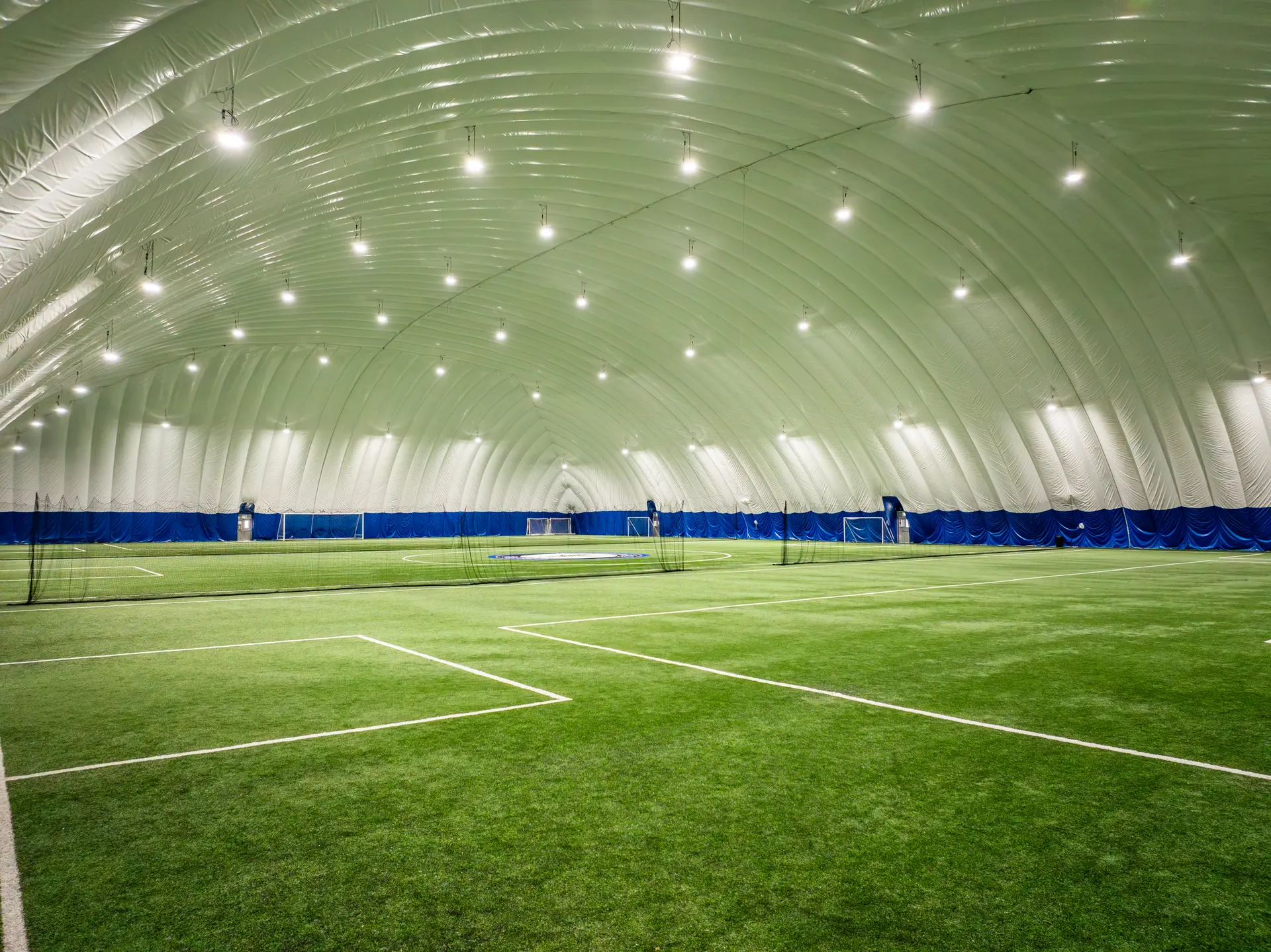 Inside the proposed Monarch Park Stadium winter dome, a lit indoor turf field